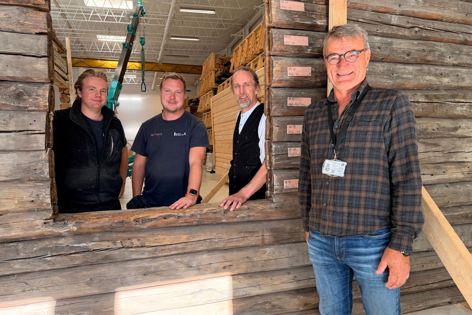 Foto av fire personer inne i en lagerhall. 