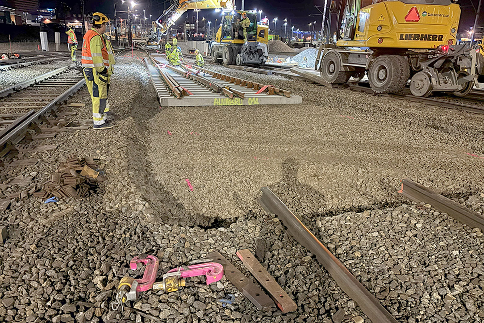 Skinnegående gravemaskiner har løftet inn vekselen, mannskap i arbeid.