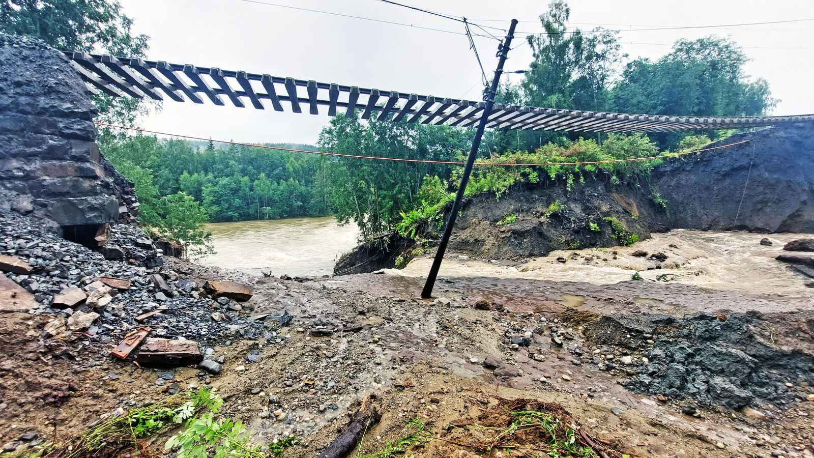 Mange meter av skinnegangen på jernbanen henger i løse lufta, over et hull i terrenget.