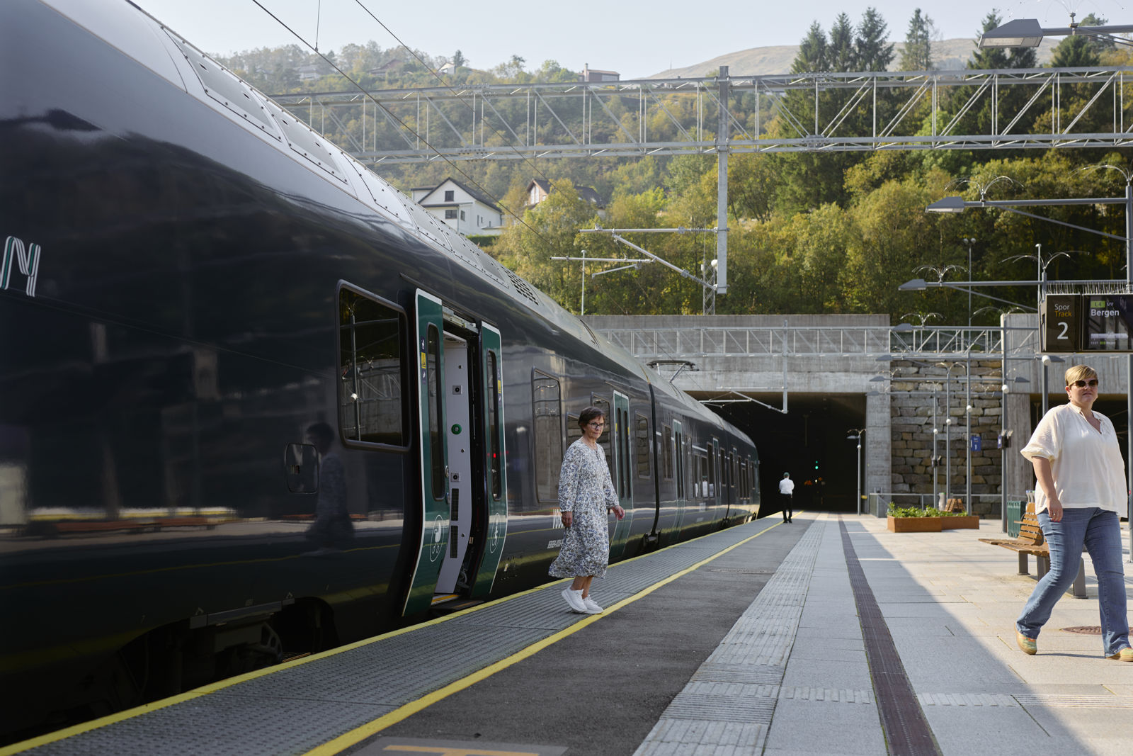 Passasjerar går av toget på Arna stasjon