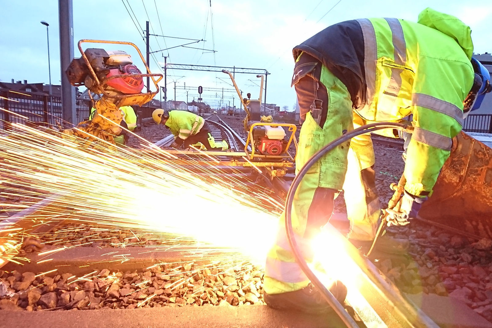 Arbeid med sveising av skinner med annet sporarbeid i bakgrunnen.