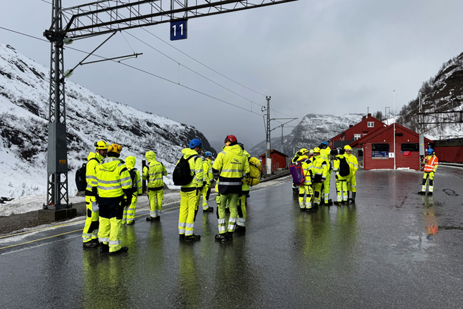 Mennesker i verneklær på en jernbaneplattform