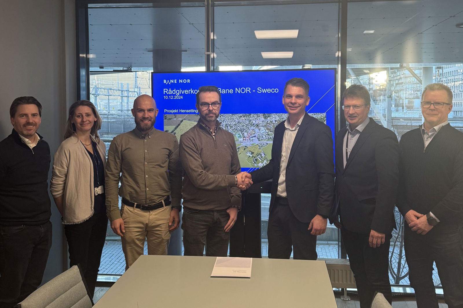 Gruppefoto av personer fra Bane NOR og Sweco etter at kontrakt er signert.