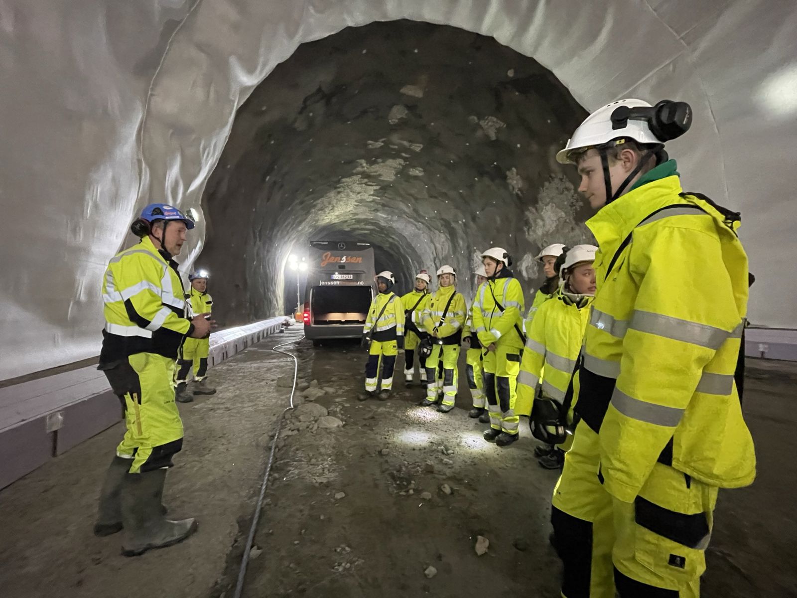 Menn og kvinner i verneutstyr avbildet i tunnel